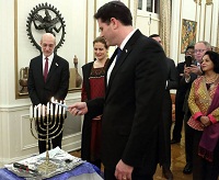 Ambassador Ron Dermer, Israel's Ambassador to the U.S., lighting the Menorah, the traditional oil lamp, on the occasion.